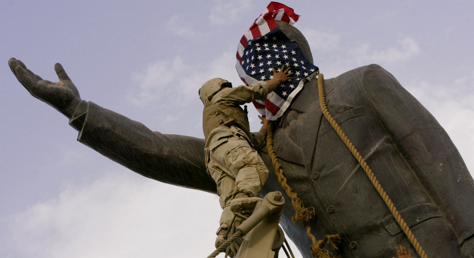 US soldier places American flag over Saddam Hussein's statue in 2003