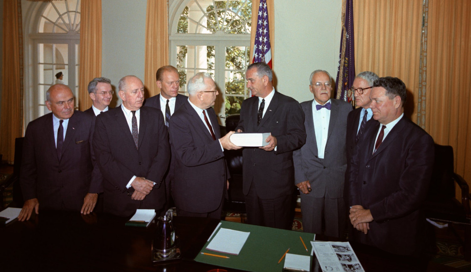 The Warren Commission delivers its report on Kennedy's assassination to President Lyndon B. Johnson on September 24, 1964. From left: lawyer John McCloy, General Counsel J. Lee Rankin, Sen. Richard Russell, Rep. Gerald Ford, Chief Justice Earl Warren, President Johnson, former CIA Director Allen Dulles, Sen. John Sherman Cooper, and Rep. Hale Boggs.